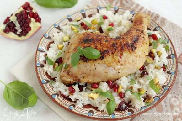 Переложите рис на тарелку, сверху выложите курицу, посыпьте рублеными фисташками, зернами граната и зеленью.