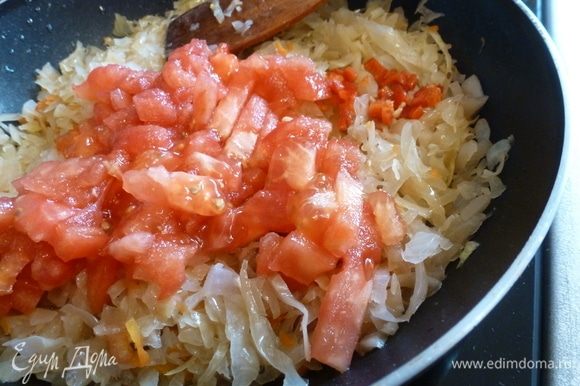 На сковороде поджарим нарезанный лук, затем добавим капусту, немного обжарим ее. С помидора снимем кожицу, нарежем кубиком и отправим к капусте.