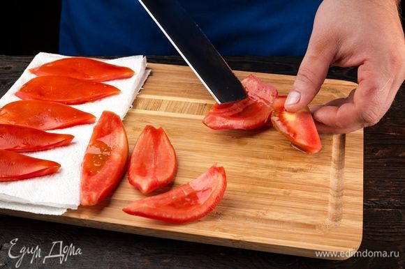 Приготовьте ароматные вяленые помидоры для закуски. Помидоры промойте, вырежьте плодоножку, разрежьте пополам и вычистите ложкой семена вместе с соком. Выложите на бумажные полотенца, чтобы убрать сок.