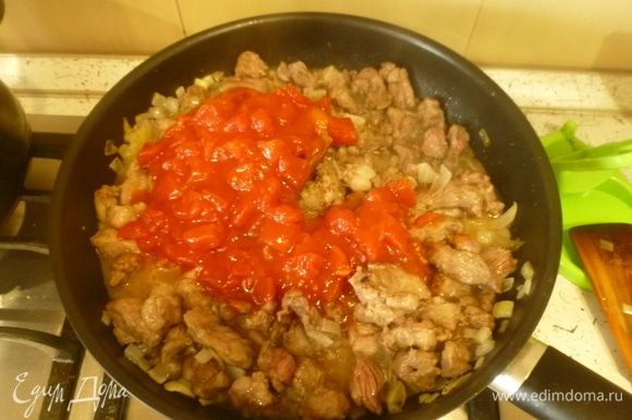 Добавить томаты. Влить часть бульона, чтобы мясо было полностью покрыто, тушить на слабом огне 1 час.