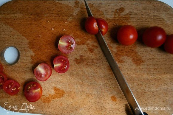 Разрезать черри пополам. Можно заменить на обычные помидоры, которые необходимо нарезать слайсами.