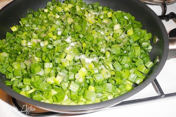 Зеленый лук (большой пучок) мелко нарезать и выложить на сковороду к зеленому горошку. Посолить, поперчить.