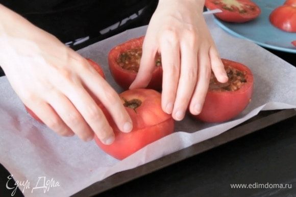 Разогреть духовку до 180°С. Накрыть помидоры крышечками, полить маслом.