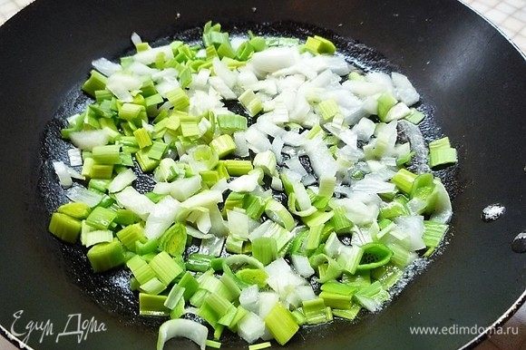 На другой сковороде в разогретом сливочном масле обжариваем мелко нарезанные лук-порей и белый лук в течение 5 минут.