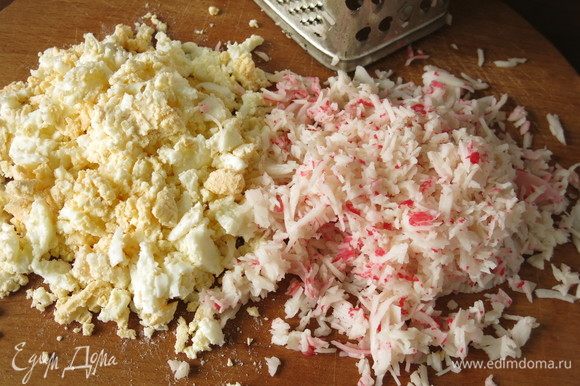 Порубим яйца и измельчим на терке крабовые палочки, мясо очень нежное, волокна легко отделяются.