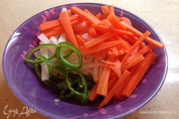 Перец чили нарезать кружочками, морковь и дайкон — тонкой соломкой. Сложить в миску.