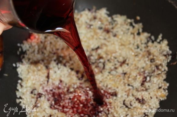 Влить вино, быстро перемешать, и буквально, сразу же, накрыть крышкой. Важно! Рис должен полностью впитать вино! Иначе, вкус ризотто в конце немного испортится. Через 1–1,5 минуты уберите крышку и постоянно перемешивайте рис до полного испарения вина. Он уже на этом этапе начнет приобретать рубиновый цвет.