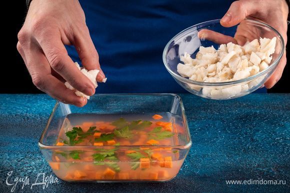 В форму налейте тонким слоем бульон и дайте ему застыть. Затем выложите морковь, зелень. Сверху положите кусочки рыбы и залейте все бульоном до краев. Поставьте формочки в холодильник на несколько часов до полного застывания. Лимон нарежьте тонкими ломтиками, используйте также оставшуюся зелень.