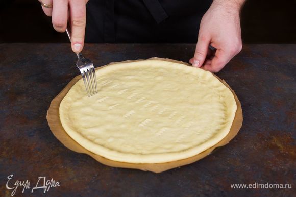 Плоское блюдо для микроволновки посыпьте мукой и на нем раскатайте тесто в тонкий пласт. Проткните тесто вилкой в нескольких местах.