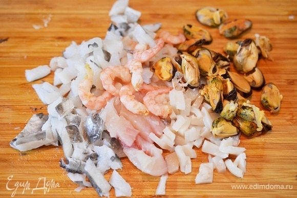 Рыбу и морепродукты разморозьте. Креветки очистите, мидии оставьте целыми, остальные ингредиенты отделите от костей и нарежьте кубиком.