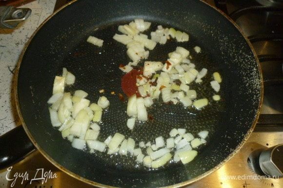 Лук мелко нарезать. Сковороду вернуть на огонь, плеснуть масло, пассеровать лук и раскрошенный чили со щепоткой соли и гвоздикой.