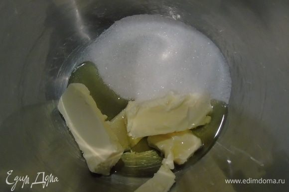 В чашу миксера всыпаем сахар, добавляем мягкое сливочное масло и оливковое масло и все взбиваем до бела.