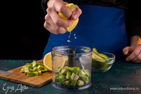 Порубите авокадо кубиками, выложите в блендер и сбрызните лимонным соком. Измельчите авокадо в блендере.