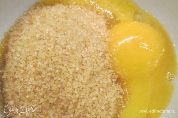 Добавляем желток, смешанный с сахаром и замешиваем в тесто.