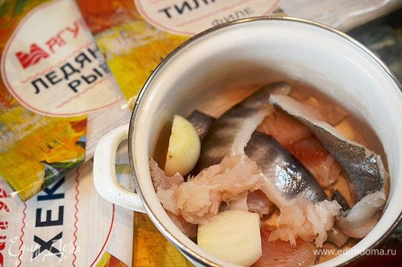 С ледяной рыбы и хека срежем филе, тилапию нарежем на кусочки, луковицу почистим и разрежем пополам.
