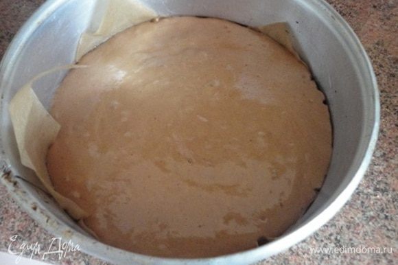 Разъемную форму диаметром 24 см смазать маслом, а дно выстелить пекарской бумагой. Вылить бисквитную массу и выпекать 35 минут в духовке при температуре 180°C.