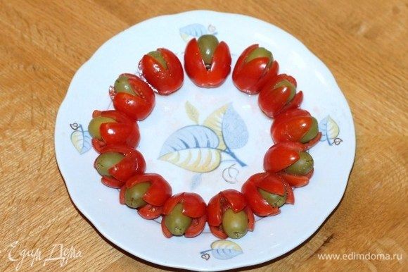 В каждом помидорчике черри (сверху) делаем острым ножиком крестообразный разрез. Кладем в разрез оливки б/к и маслины б/к, получается 18 шт.