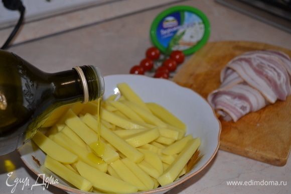 Филе обернуть беконом. Картофель почистить, нарезать брусочками. Посолить, добавить оливковое масло, перемешать.