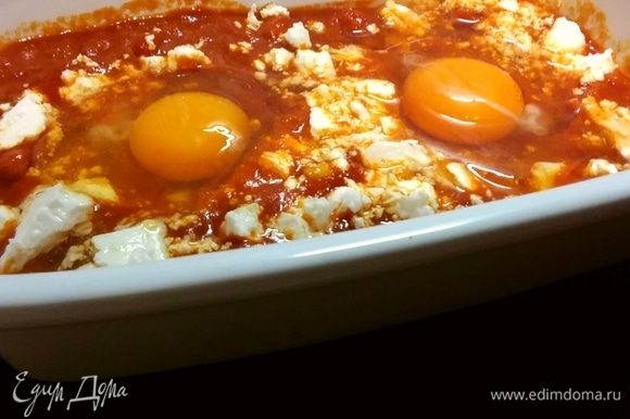 Чтобы закончить шакшуку индивидуально, предварительно разогрейте духовку до 180ºС. Разделите соус по формам для выпечки и распределите кубики феты в соусе. Сделайте углубления (по 2 на порцию) и выложите яйца в лунки. Выпекайте до тех пор, пока яйца не будут приготовлены по вашему вкусу. Это займет от 10 до 15 минут, но начните проверять их раньше, чтобы получить их в самый раз. Если желтки начнут немного укрепляться сверху, накройте форму листом фольги, но не прикасайтесь к желткам.