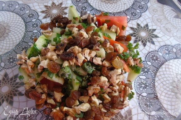 В салатнике смешайте нарезанный зеленый лук, огурцы, помидоры, орехи, изюм.
