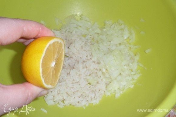 Остуженный рис выкладываем в чашку. Добавляем мелко нарезанный лук и сок половины лимона.