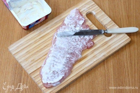 Смазать кусочки мяса плавленным сыром.