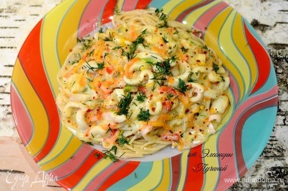 Готовые спагетти выложить в центр тарелки и сверху полить нашей нежной подливой с кальмарами, посыпать зеленью и перцем.