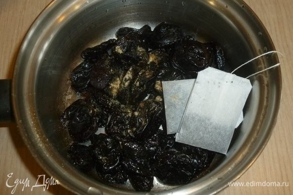 Чернослив, пакетики с чаем, имбирь и гвоздику сложить в сотейник, залить кипятком, чтобы чернослив был полностью в воде. Оставить на 10 минут, воду слить.