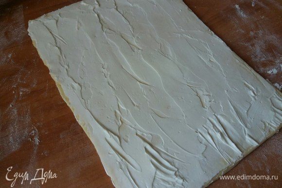 Скалкой аккуратно в одном направлении раскатать тесто, не слишком тонко, примерно 3–5 мм. Намазать слоем сливочного сыра.