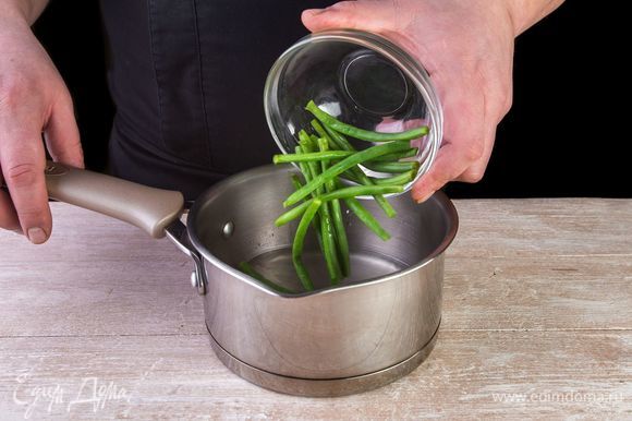 Доведите до кипения кастрюлю с водой, высыпьте зеленую фасоль и проварите 2–3 минуты. Откиньте фасоль на дуршлаг.