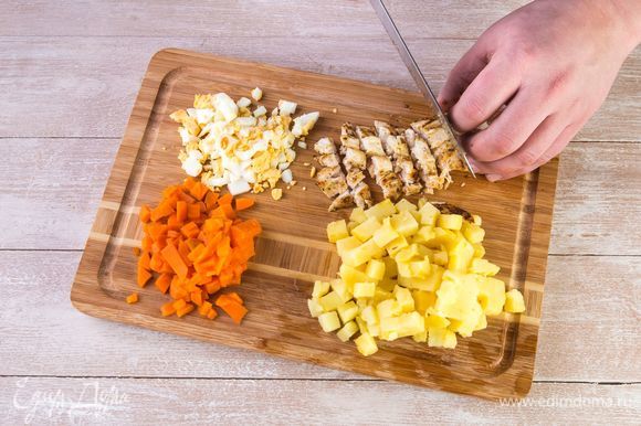 Нарежьте картофель, морковь, яйца и куриное филе одинаковыми кубиками.
