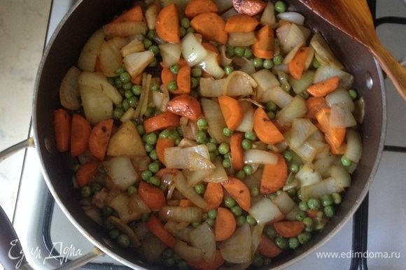 В сотейнике, где жарились ребра, добавить растительное масло и обжарить морковь, лук и зеленый горошек буквально пару минут до золотистости.