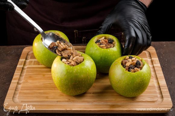 Нафаршируйте яблоки плотно смесью сухофруктов и орехов. Каждое яблоко заверните в фольгу, оставив сверху небольшое отверстие. Запекайте 35 минут при 180°С.
