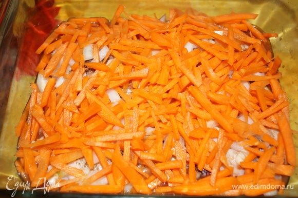 Когда курица замариновалась, выкладываю кусочки мяса в форму из жаропрочного стекла. Сверху равномерно добавляю нарезанные лук и морковь. Можно немного посыпать любимыми специями и нарубленной зеленью.