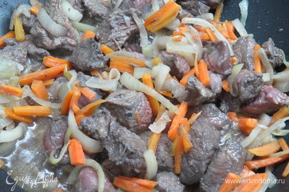 Добавить в сковороду к луку и моркови замаринованное мясо (маринад предварительно слить, но не выливать), обжарить до румянца.