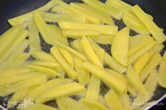 Разогреть в сковороде оливковое масло, выкладывать картофель небольшими порциями в один слой и обжаривать до появления золотистой корочки.
