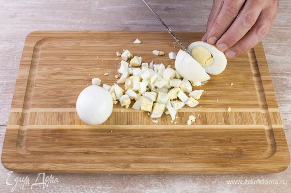 Сварите яйца вкрутую, очистите от скорлупы, нарежьте мелким кубиком.