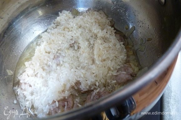 Кладем рис и немного обжарим его, пока не впитает в себя масло и не станет прозрачным.