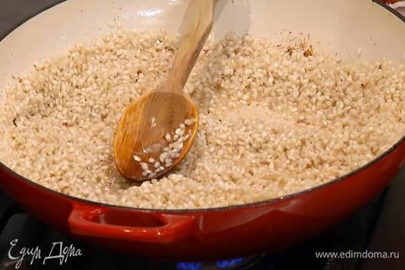 В сотейник с маслом всыпать рис и сделать тостатуру: прогревать, постоянно помешивая, 1–2 минуты, пока рис не станет прозрачным.