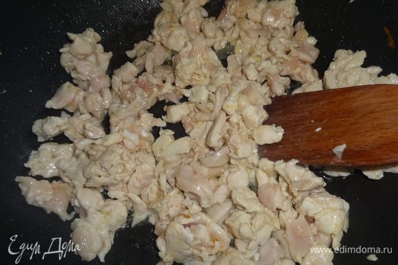 Влить в сковороду часть масла, разогреть и обжарить на нем кусочки курицы в течение нескольких минут.