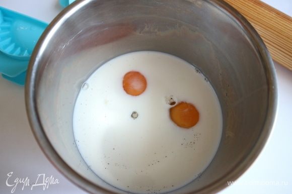 В молоко добавить яйца, ванильный сахар и ванильную эссенцию. Перемешать.