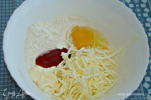 Добавить яйцо, майонез, кетчуп, соль и натертый на мелкой терке сыр.