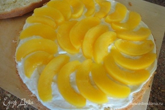 Для пропитки 50 мл сиропа от персиков смешайте с лимончелло и пропитайте бисквит, разрезанный на два коржа. Смажьте один корж половиной крема и выложите большую часть долек персиков.