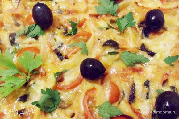Готовую пиццу можно украсить зеленью, маслинами и помидорами черри.