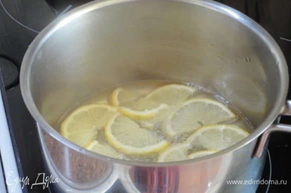 Пока кекс выпекается, приготовим декор — карамелизированые лимонные дольки и лимонную посыпку. Для этого один небольшой лимончик нарезать тонкими колечками, а затем еще на половинки. В кастрюльке смешайте 100 мл воды и 75 г сахара. Варите лимоны на медленном огне не менее 10 минут.