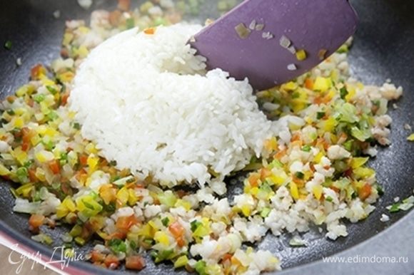 Выложите рис на сковороду и хорошо перемешайте.