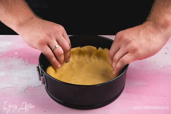 Разъемную форму диаметром 20 см смажьте сливочным маслом. Охлажденное тесто раскатайте, выложите в форму, сформируйте высокие бортики.