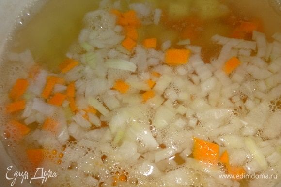 Добавить нарезанные лук и морковь в кастрюлю с картофелем.