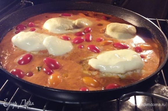 В соус выложить куриное филе и помидоры черри, кружочки моцареллы положить на мясо. Запекать в заранее разогретой до 180°C духовке около 15–20 минут.