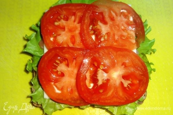 На сыр выложить кружки помидоров.
